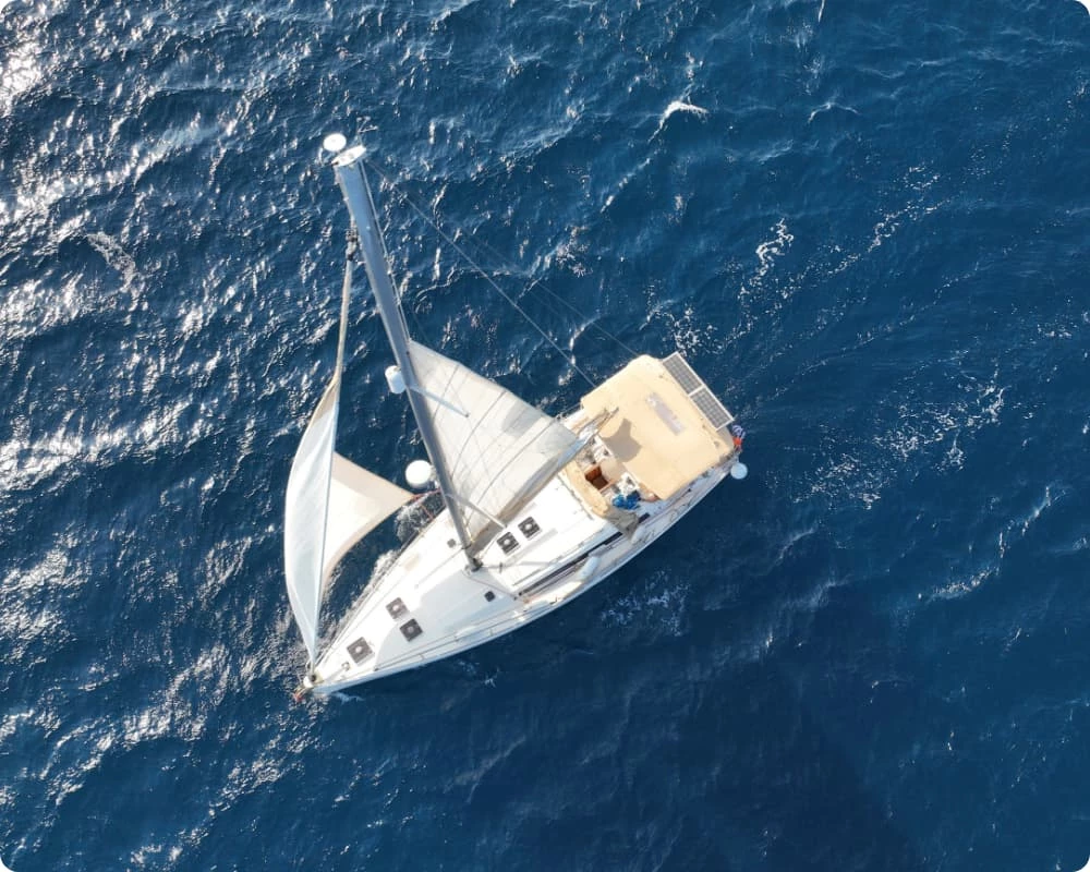 Photo de drone Aérien de bateau à voile de luxe croisant près de dans la baie paradisiaque d'Ornos dans l'île de Mykonos, Cyclades, Grèce